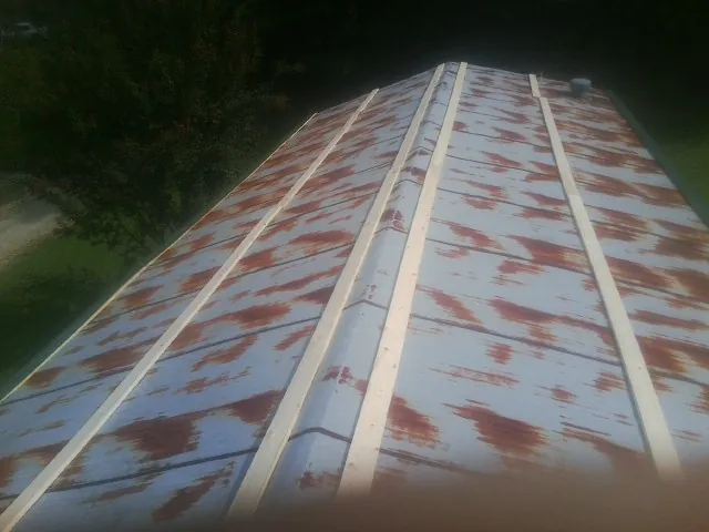 Rusted metal roof panels with new wood purlins before replacement — Storm Damage Roof Repair in Jeddo by Roofing Brothers