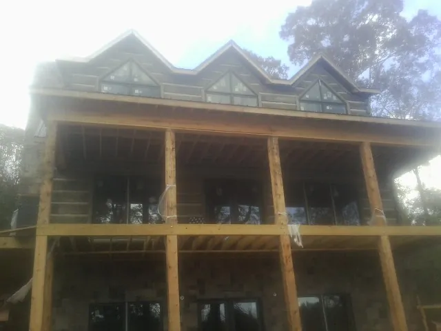 Dormers and porch framing on a large log home under construction — Roof Coating work by our crew in Jeddo