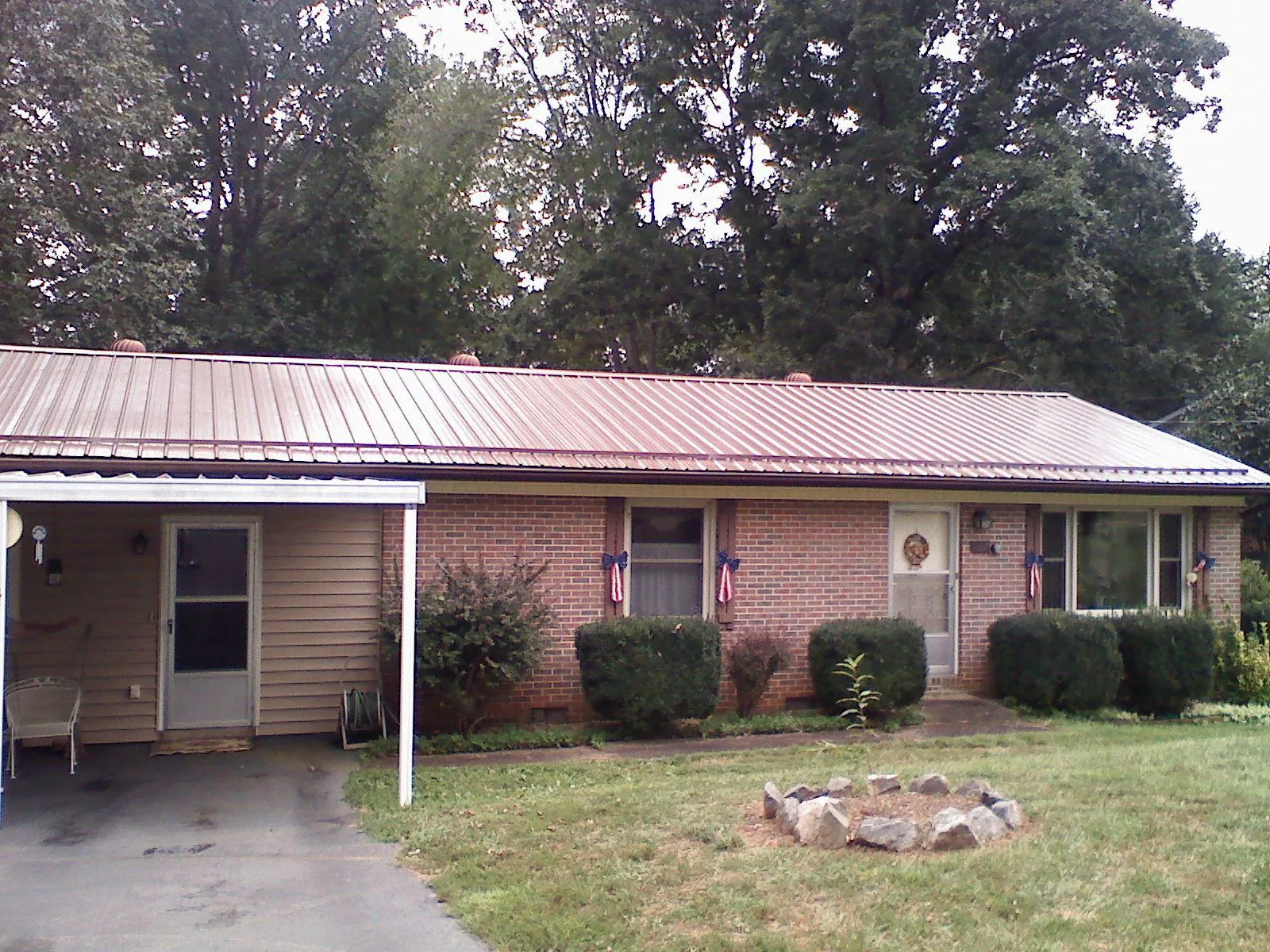 Bronze metal roof and carport on a brick ranch home — Roof Repair work by our crew in Jeddo